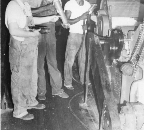 Photo of African American men working on a loom machine
