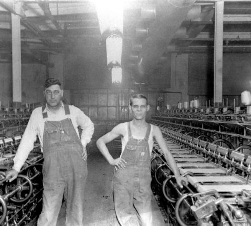 Photo of two men posing with machinery