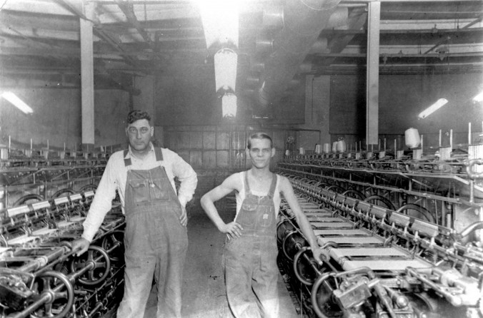 Photo of two men posing with machinery