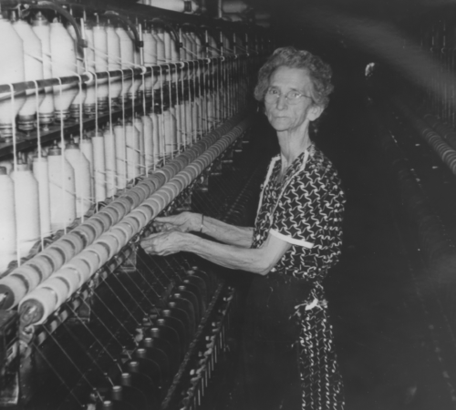 Photo of an elderly woman working on mill machines