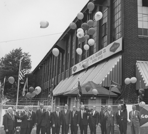Photo of men in front of the Goodyear plant releasing ballons