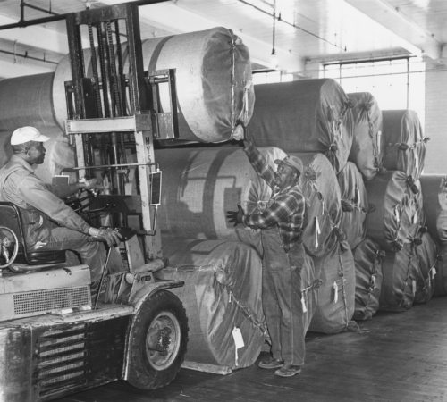 Photo of African American workers loading product with forklift