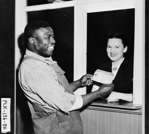 Photo of Mill worker receiving his paycheck